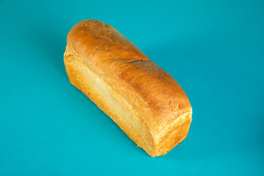 A loaf of Polly's Pies white bread on a blue background.